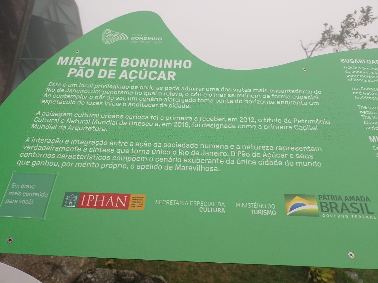 Placa situada no Mirante Bondinho Pão de Açúcar, com escrita em branco e em braille.